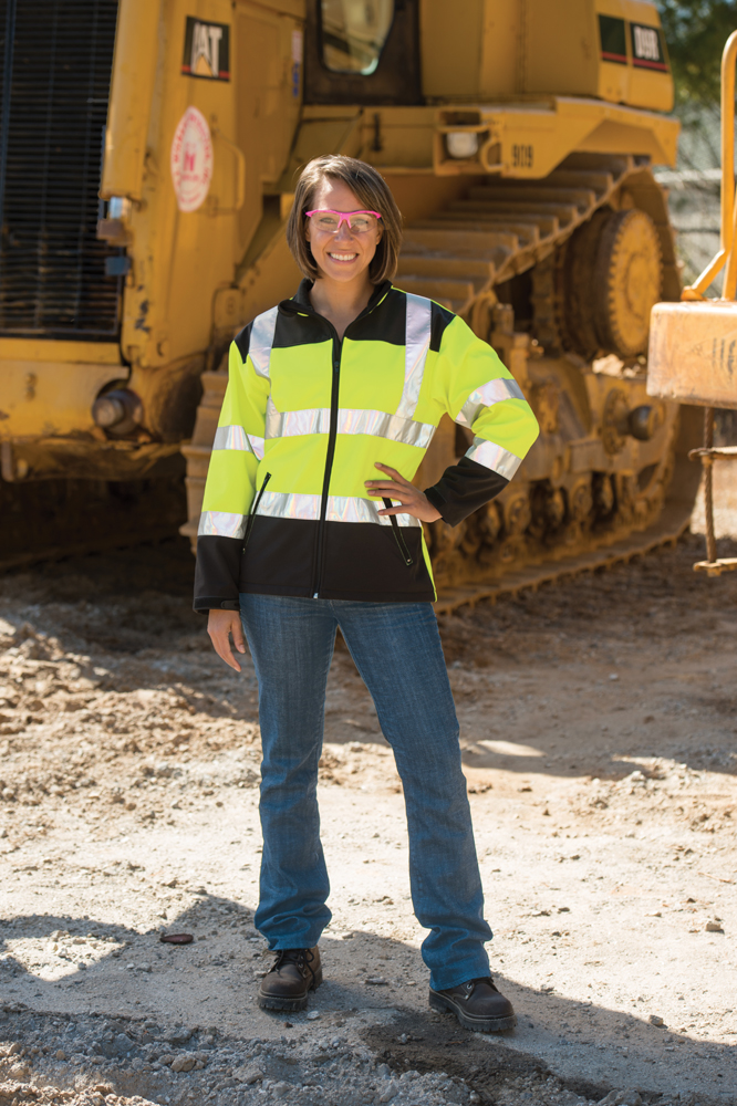 Woman standing on construction site with women's fr clothing