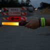 person holding a foxfire baton flashlight and wearing a foxfire wrist band in construction site