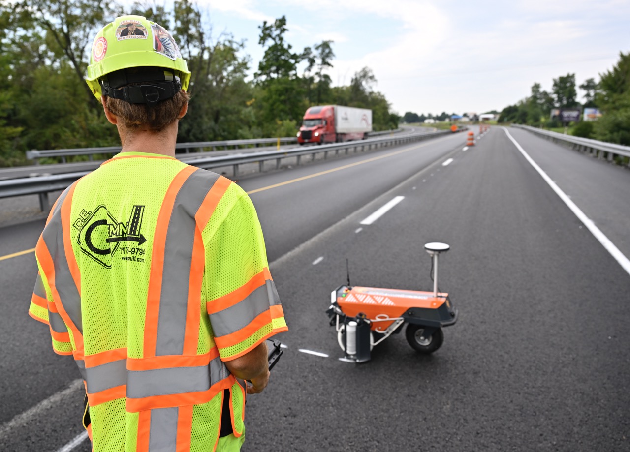 D.E. Gemmill worker operating the Tyker Robotic Plotter on a newly paved highway lane.